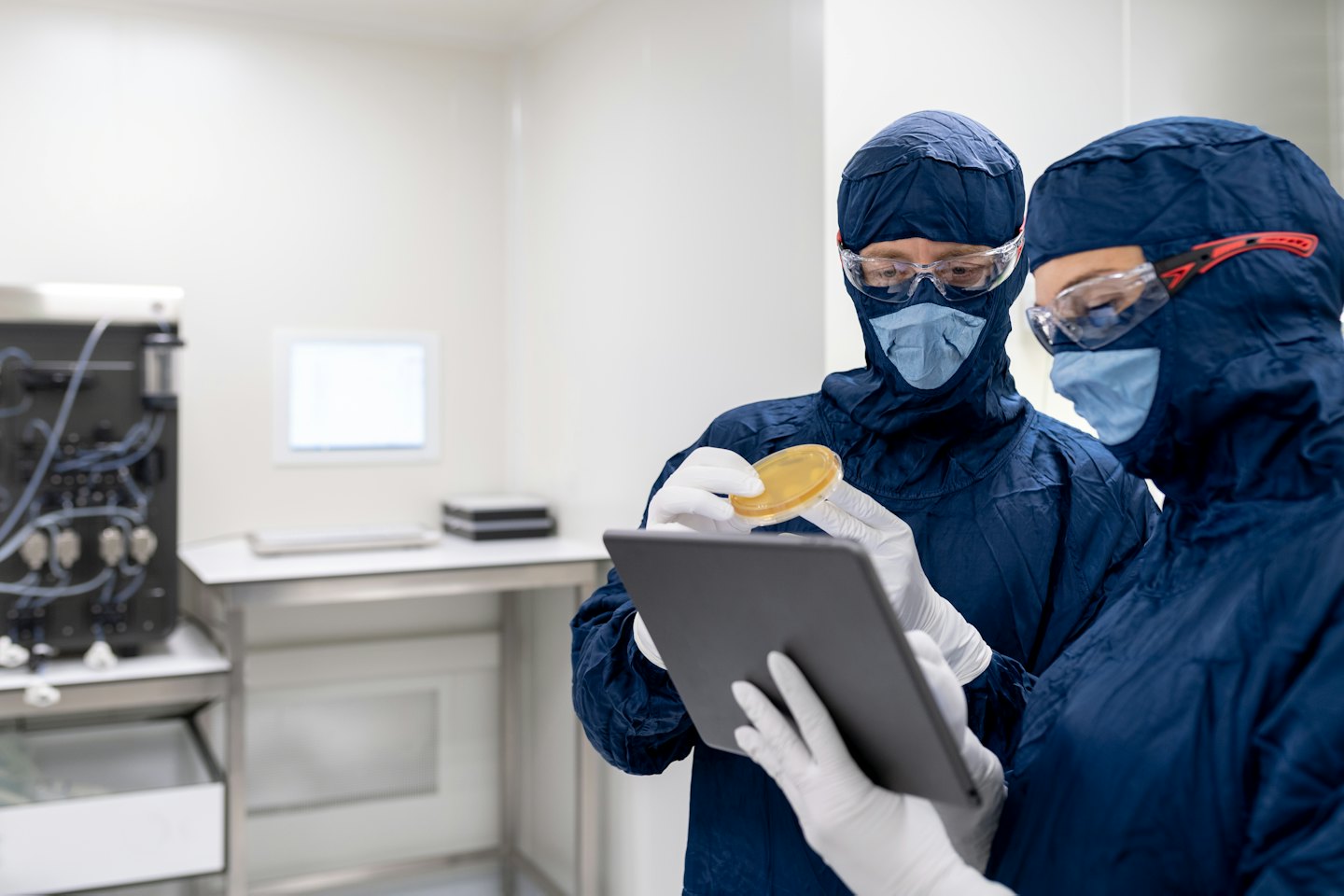 Scientists examining a petri dish in a sterile laboratory.